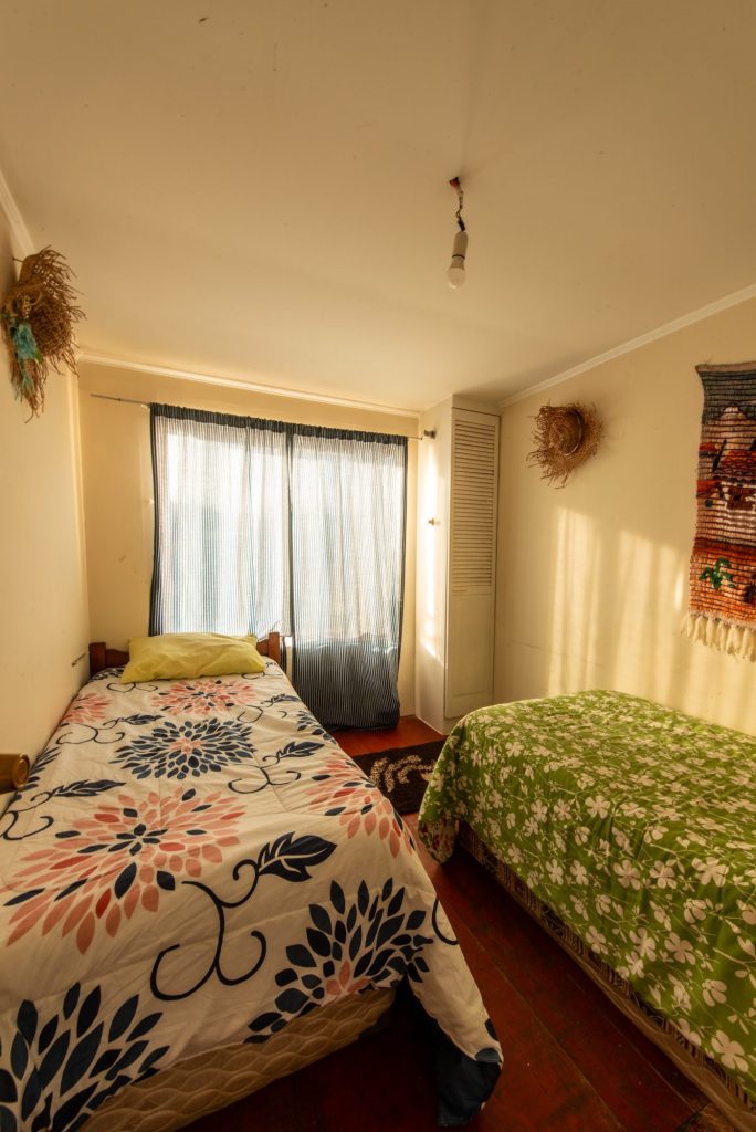 Dormitorio con dos camas y ropa de cama floral